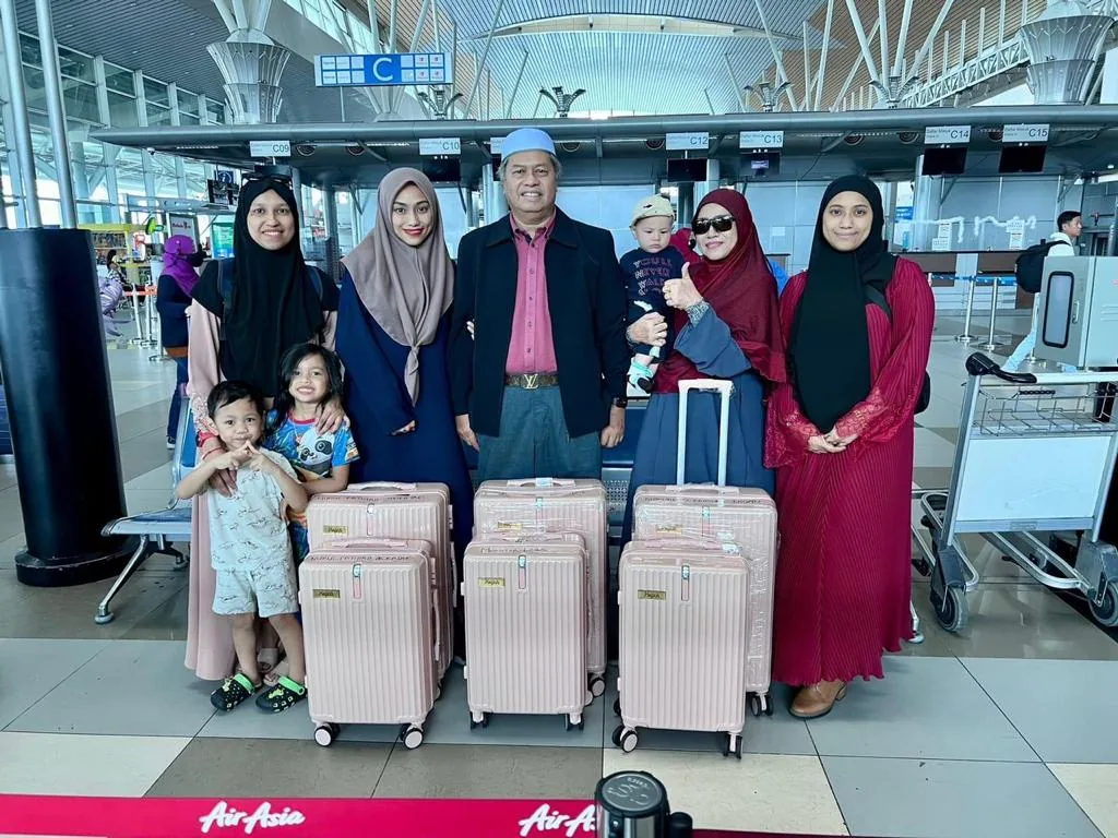A family with their pink KIYO cases at the airport check-in before departing for UMRAH