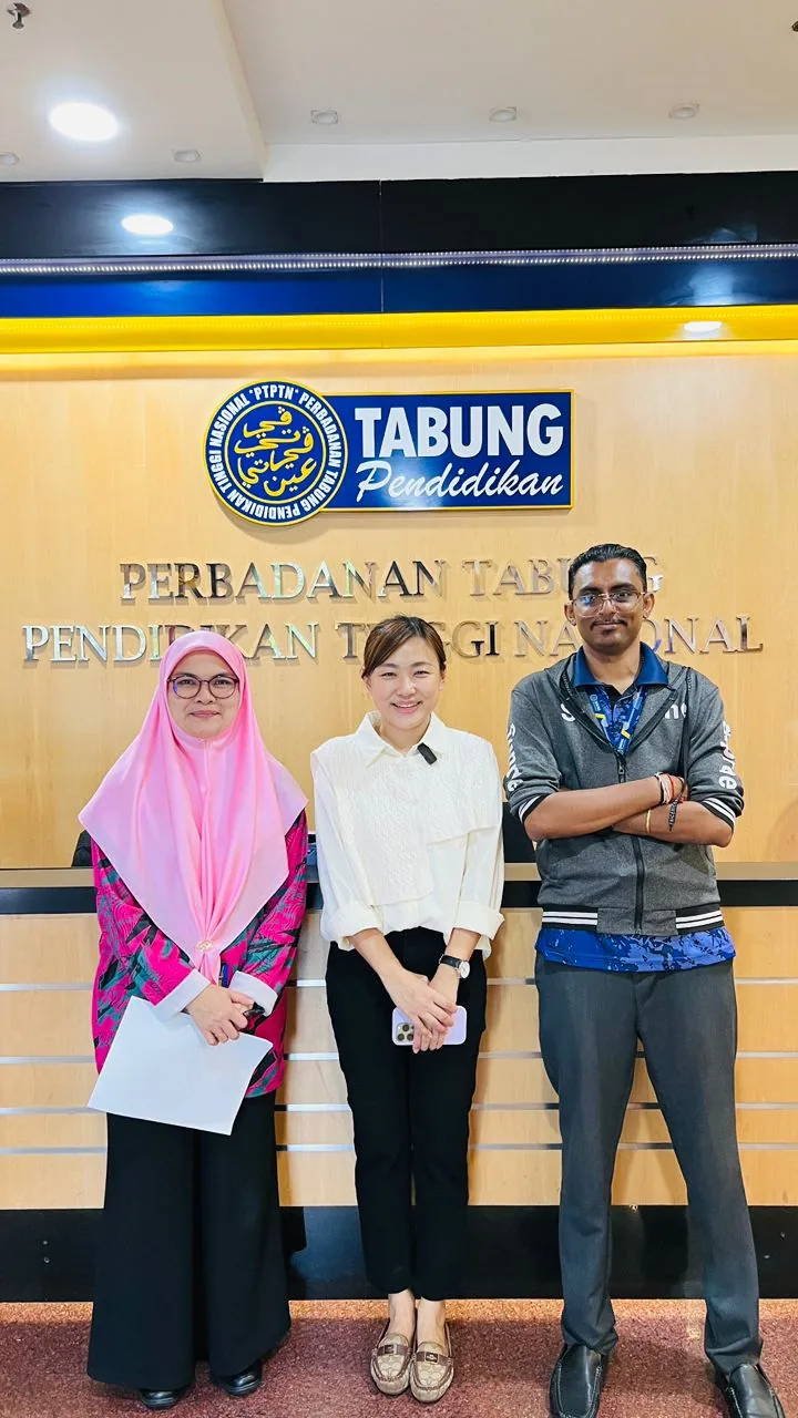 A handover photograph in front of the Perbadanan Tabung Pendidikan Tinggi Nasional sign